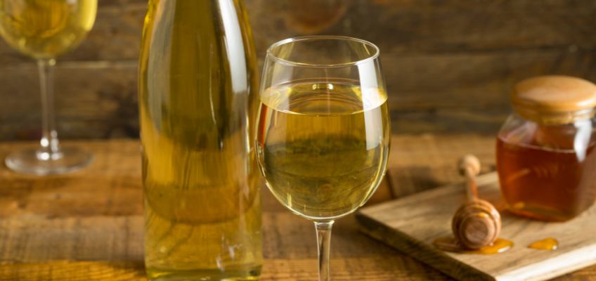 mead in wine glass near glass bottle